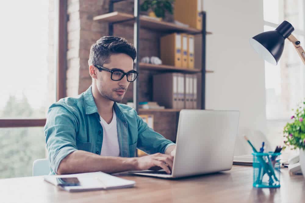 Smiling male professional working on laptop