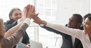 Happy diverse employees giving high five together